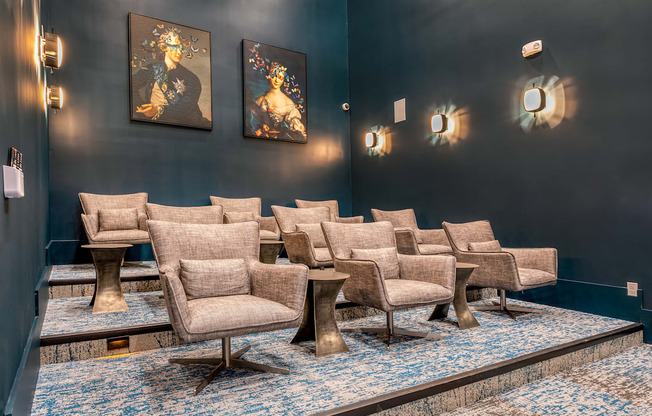 A row of chairs are lined up in a room with blue carpet.