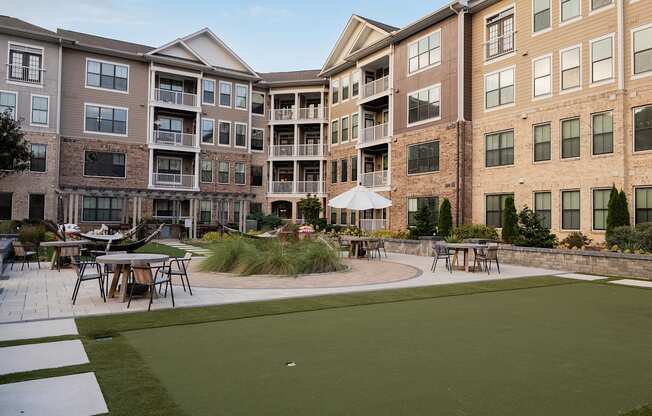 A large grassy area in front of apartment buildings.