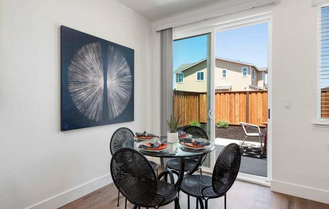 a dining room with a table and chairs and a sliding glass door