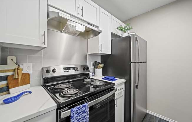 a kitchen with white cabinets and stainless steel appliances