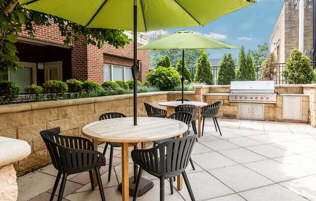 A patio with a table and chairs under a green umbrella.