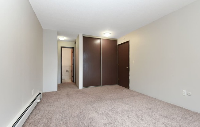 a bedroom with carpet and doors to a closet. Roseville, MN Rosedale Estates