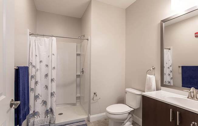A bathroom with a toilet, sink, and shower.