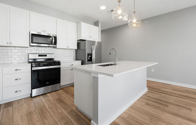A kitchen with white cabinets and a wooden floor at Madison Prickett Preserve, Yardley