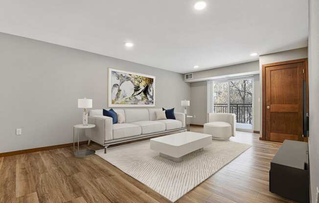 Georgetown on the River Apartments, Fridley, Minnesota. A living room with a white couch and coffee table on a white rug.