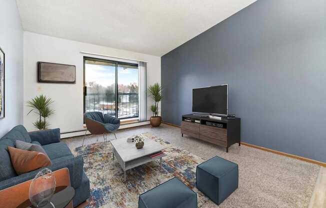 A living room with a grey couch, a coffee table, and a television.