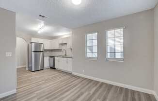 a kitchen with white cabinets and a stainless steel refrigerator