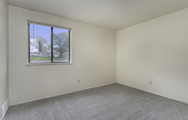 Large bedoom with a window and carpeting