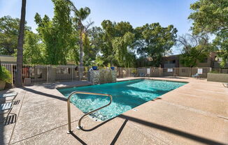 a swimming pool with a fence around it and trees