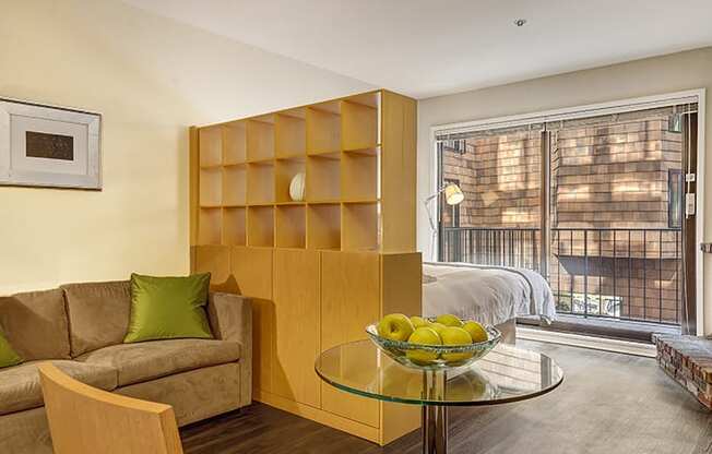 a living room with a couch and a table with a bowl of fruit on it