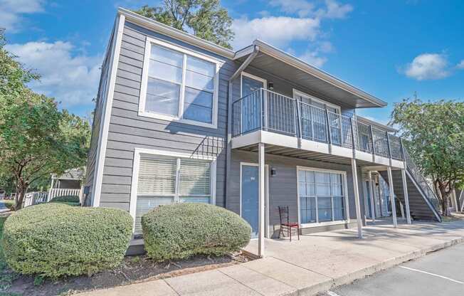 A grey two-story apartment building with the entrance to 4 units at Maplewood apartments in Shreveport, LA.