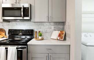 A modern kitchen with a black stove top oven and a white dishwasher.