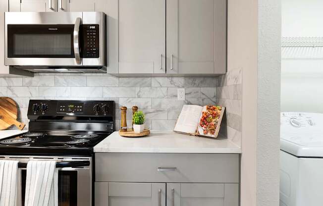 A modern kitchen with a black stove top oven and a white dishwasher.