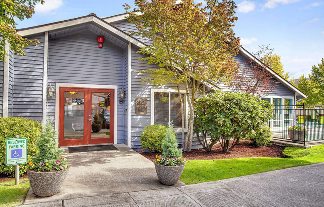 the front of a blue house with a red door