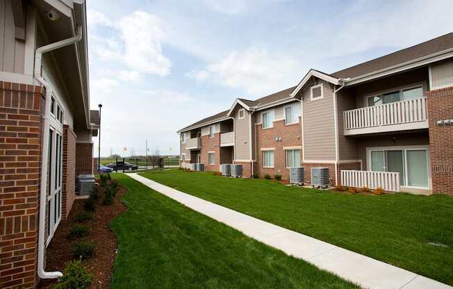 A row of houses with a sidewalk in front.