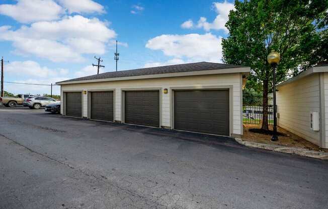 A building with a grey roof and a white wall with a black garage door.