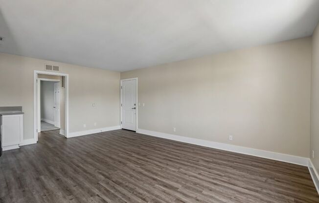 A room with wooden flooring and white walls