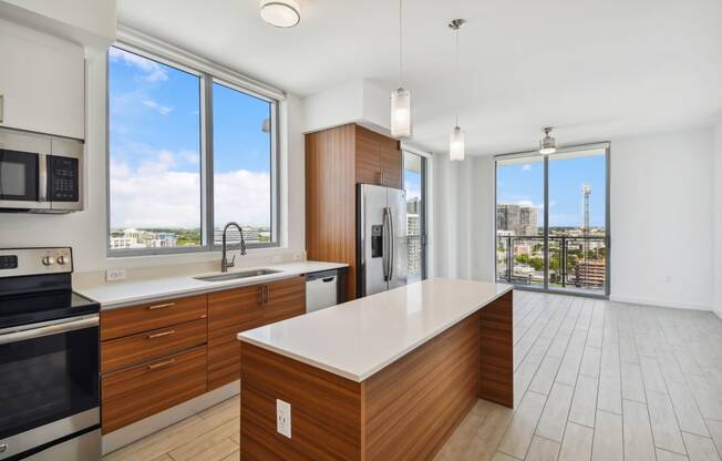 a kitchen with wooden cabinetry and a large center island with a white countertop