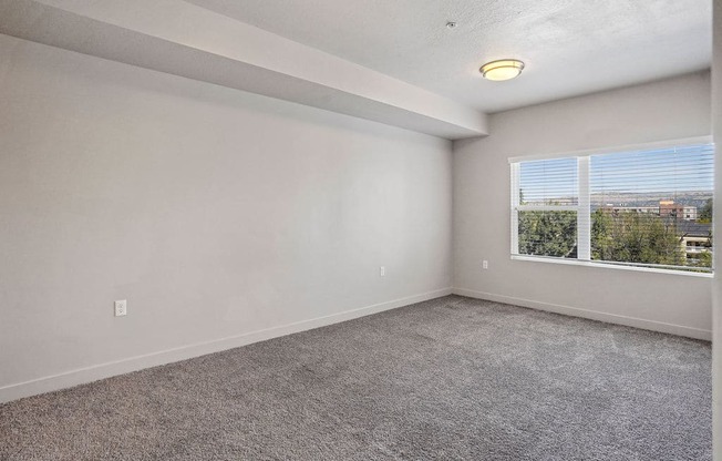 an empty bedroom with a large window