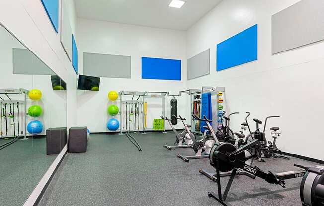 a gym with exercise equipment and weights on the wall