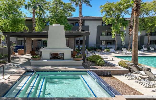 poolside covered lounging area with a fireplace at Avora apartments