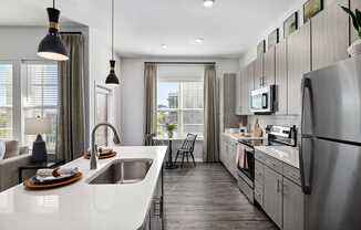 A modern kitchen with a large island and stainless steel appliances.