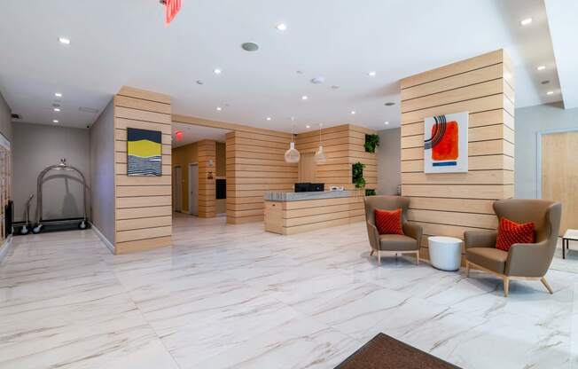 the lobby of a hotel with chairs and a desk