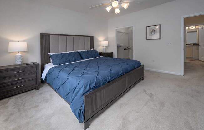A bedroom with a large bed and a ceiling fan.