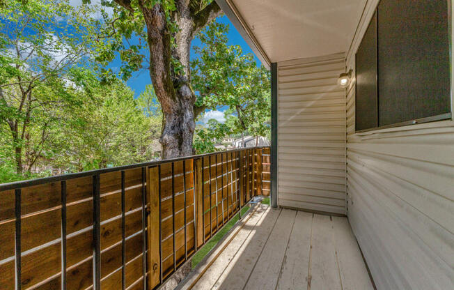 a large deck with a tree and a blue sky in the background