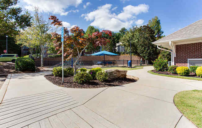 a driveway leading to a house with a playground and trees