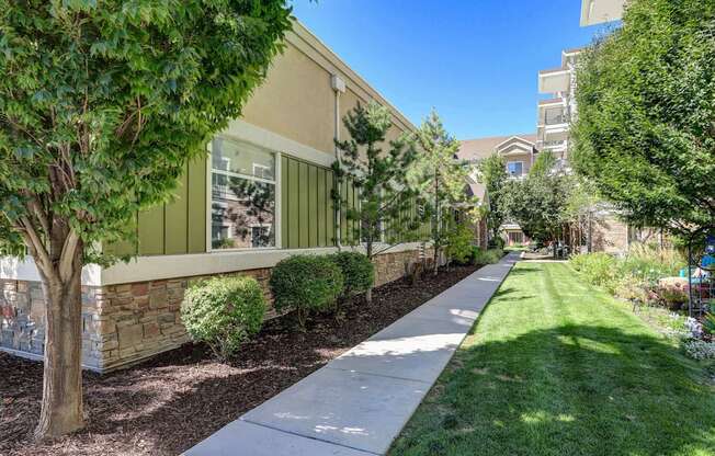 a walkway with trees and bushes in front of a building at The Beckstead, South Jordan, Utah