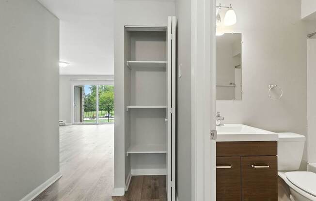 A white bathroom with a large mirror and a white sink.