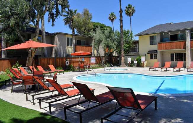 beautiful pool surrounded by lounges, tables, and umbrellas. available to all residents