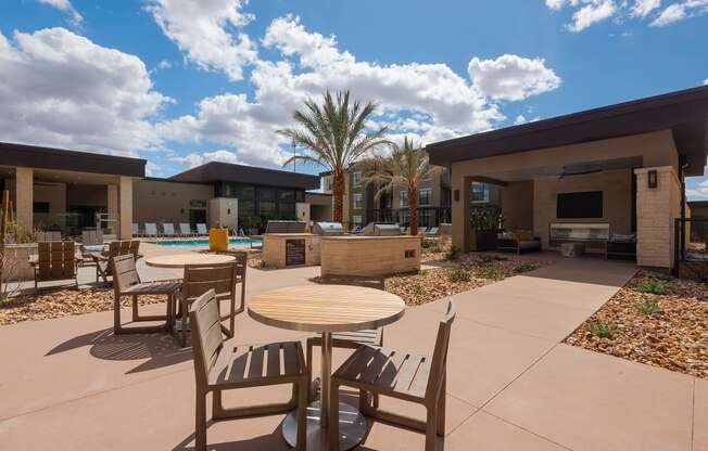 pool area with tables and chairs at escape at arrowhead's apartments in glendale, az