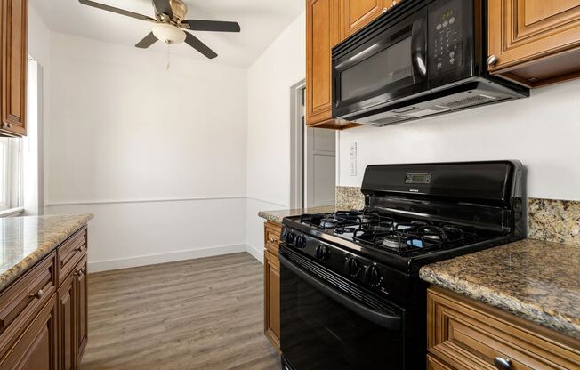 a kitchen with wooden cabinets and a black stove top oven