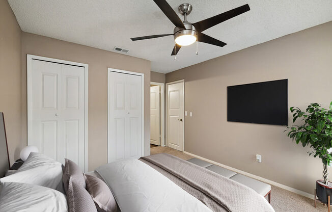 Model bedroom with a bed and a ceiling fan at Vue at Baymeadows Apartments in Jacksonville, Florida