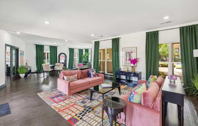 a living room with pink furniture and green curtains