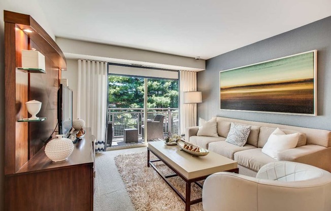 A modern living room with a wooden cabinet, a white sofa, a coffee table, and a large painting on the wall.