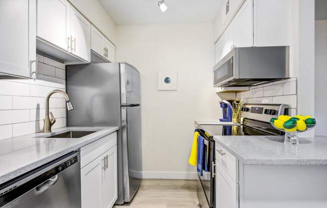 a kitchen with white cabinets and stainless steel appliances