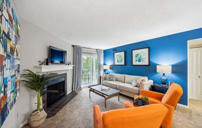 A living room with a fireplace, a couch, a chair, and a television.