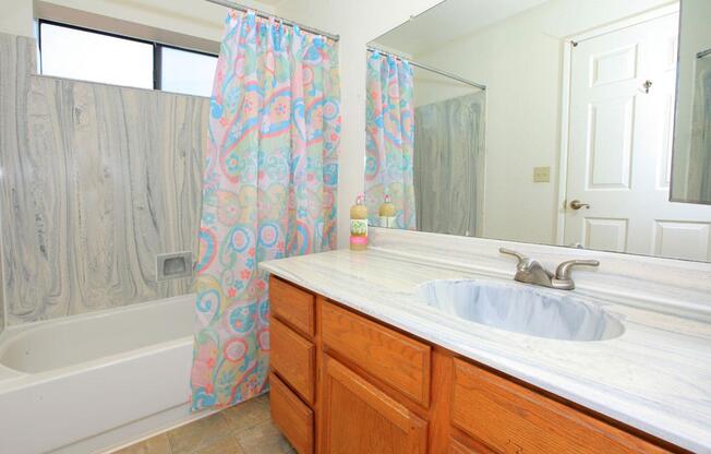 a bedroom with a large tub next to a sink