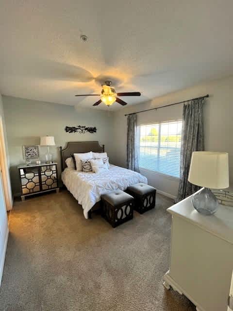 A bedroom with a bed, nightstand, and window.