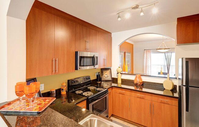 Kitchen with black granite countertops; opening to separate dining room