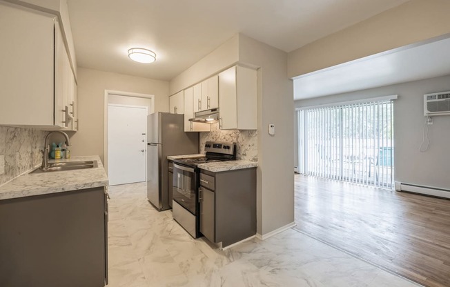 an open kitchen with stainless steel appliances and marble counter tops