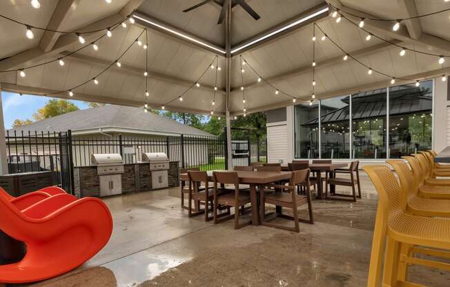 a patio with tables and chairs and a grill