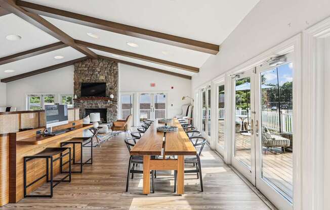 A modern dining room with a stone fireplace and wooden floors.