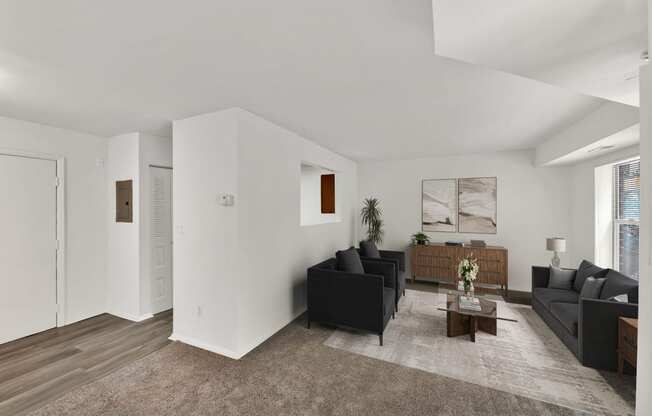 a living room with two black couches and a coffee table