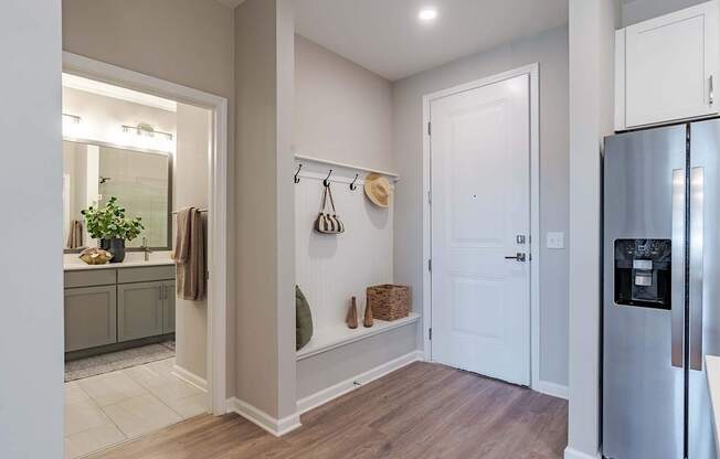a hallway with a refrigerator and a door to a kitchen