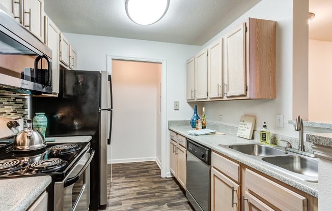 Model kitchen at our apartments in Antioch, featuring wood grain floor paneling and stainless steel appliances.