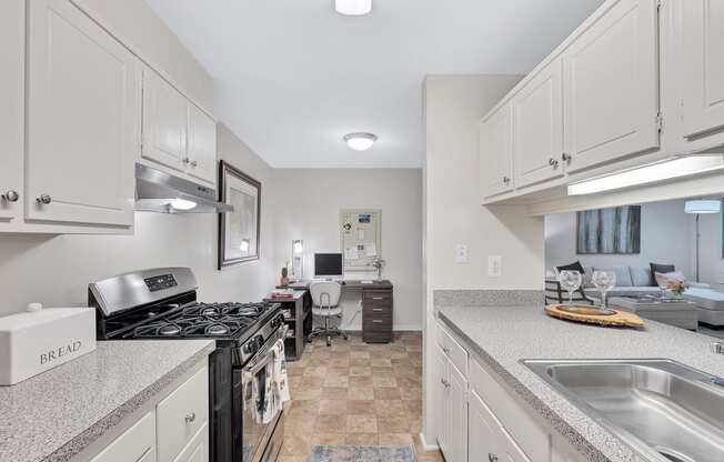 a kitchen with white cabinets and a black stove top oven